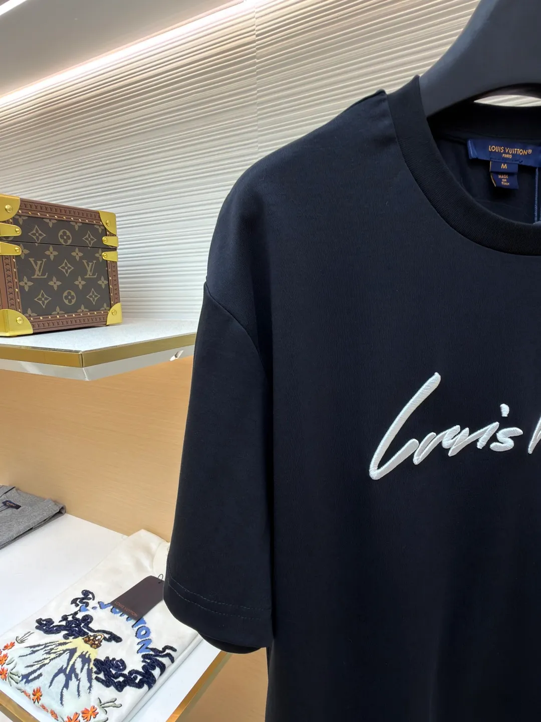 LOUIS VUITTON round neck short sleeves with hand lettering embroidery ●Item number: 1681408-X95 ●Material: long-staple cotton fabric ●Technology: embroidery production ●Color: black ●Version: fitted version ●Weight: about 230 grams ●Size: S-M-L-XL ●Description: Restore 60S single yarn double-sided long-staple cotton, weight 170g; with 32S 1×1 thread, 300g. After being treated with liquid ammonia, it looks like a water-gloss machine. The cloth surface is smooth and has a clear texture, with a slight luster and strong texture. The cotton fiber length of the fabric is long. The advantage of this feature is that after being spun into yarn, the surface of the yarn is smoother, less rough and has a delicate feel. The thin and long features give it a flexible texture, soft skin feel and fabric luster. The front side shows the thickness changes of 3D handwritten font embroidery handwriting strokes and the design pattern after the continuous strokes are simplified; the three-dimensional effect is achieved through multi-layer embroidery threads, filling materials and special stitching methods. Jagged edges are prone to appear on curves and corners; add foam embroidery to the bottom layer of the embroidery and then cut off the excess to form a three-dimensional bulge and improve the smoothness of the lines. Standard H hanging fit with shoulder-length design. The vertical version emphasizes that the width of the shoulders, waist, and hem are basically the same, and it is simple and loose. The short sleeves are tailored to fit the body of the wearer. At the same time, the neckline, cuffs and hem of the short sleeves are all designed with double lines. The overall wiring is straight and delicate, the fabric is comfortable and soft, and the color is consistent without color difference. It can be matched with the same style to create a fashionable look and control various occasions. Customized accessories, complete with three standards, same style for men and women!